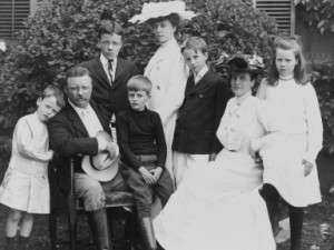 Pres. and Mrs. Theodore Roosevelt seated on lawn, surrounded by their family; 1903. From left to right: Quentin, Theodore Sr., Theodore Jr., Archie, Alice, Kermit, Edith, and Ethel. Photo courtesy Library of Congress.